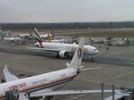 Emirates-Boeing 777-300ER beim Rollen zur Startbahn in Frankfurt am Main und eine AeroLogic-Boeing 777-200LRF bei der Landung