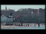 Ein Motorschirmpilot fliegt den Strand von Ahlbeck entlang und zu dieser Zeit zieht ein Flugzeug seinen Kondensstreifen über den zunehmenden Mond.